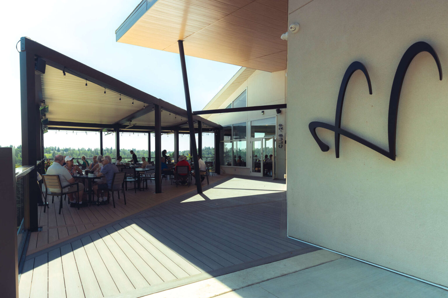 Aluminum patio with people dining at Highlands Golf Club in warm weather.