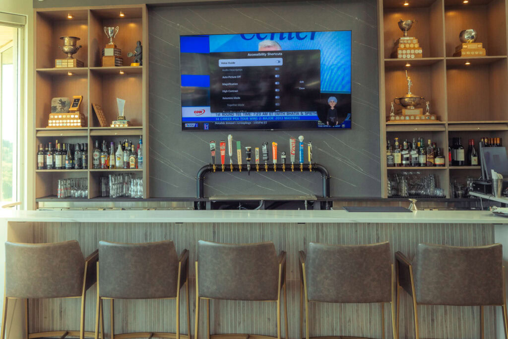 Modern Highlands Golf Club bar with flat-screen TV and craft beer taps.