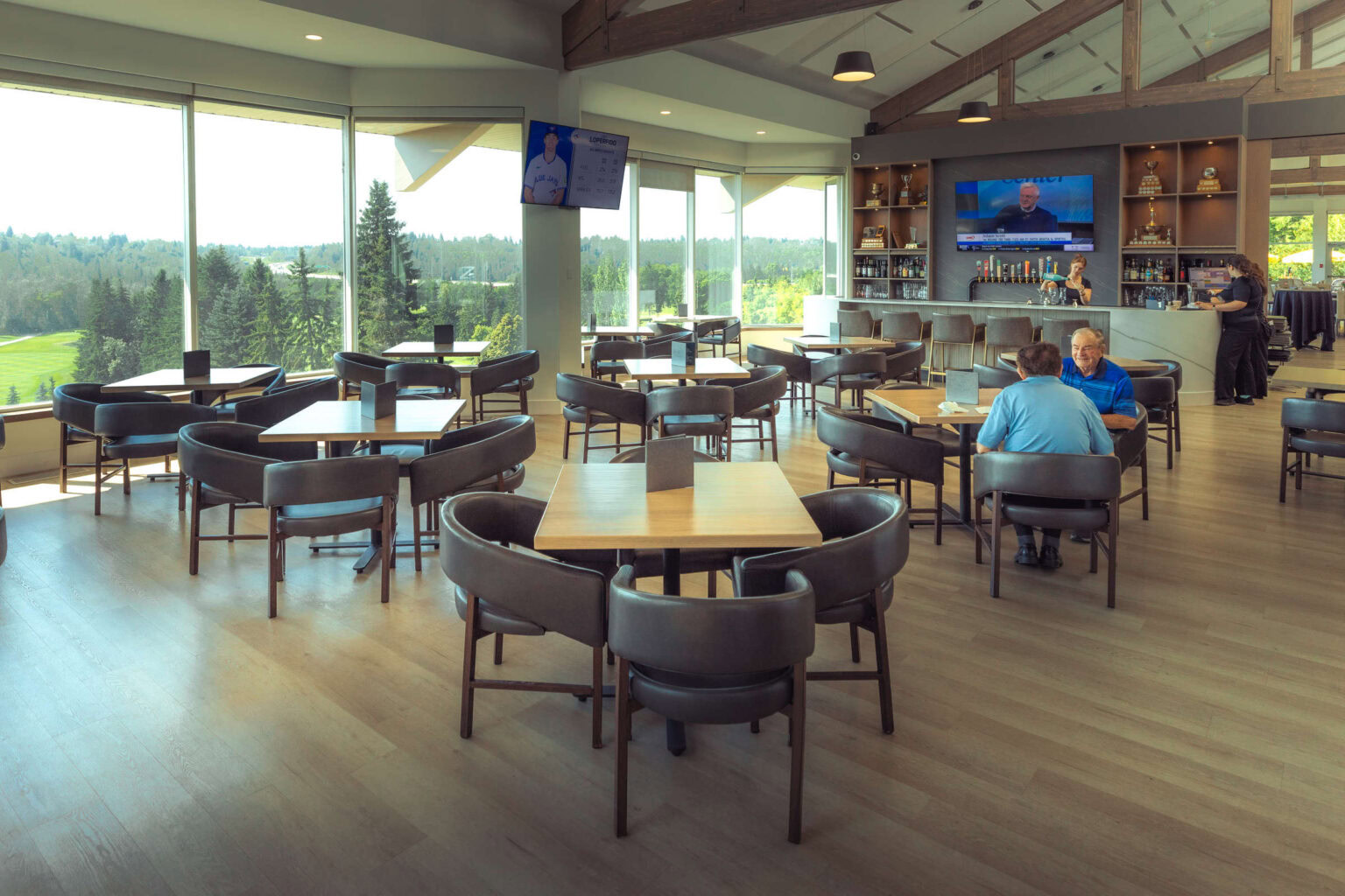 Bright indoor golf clubhouse with panoramic views of the golf course and modern amenities.