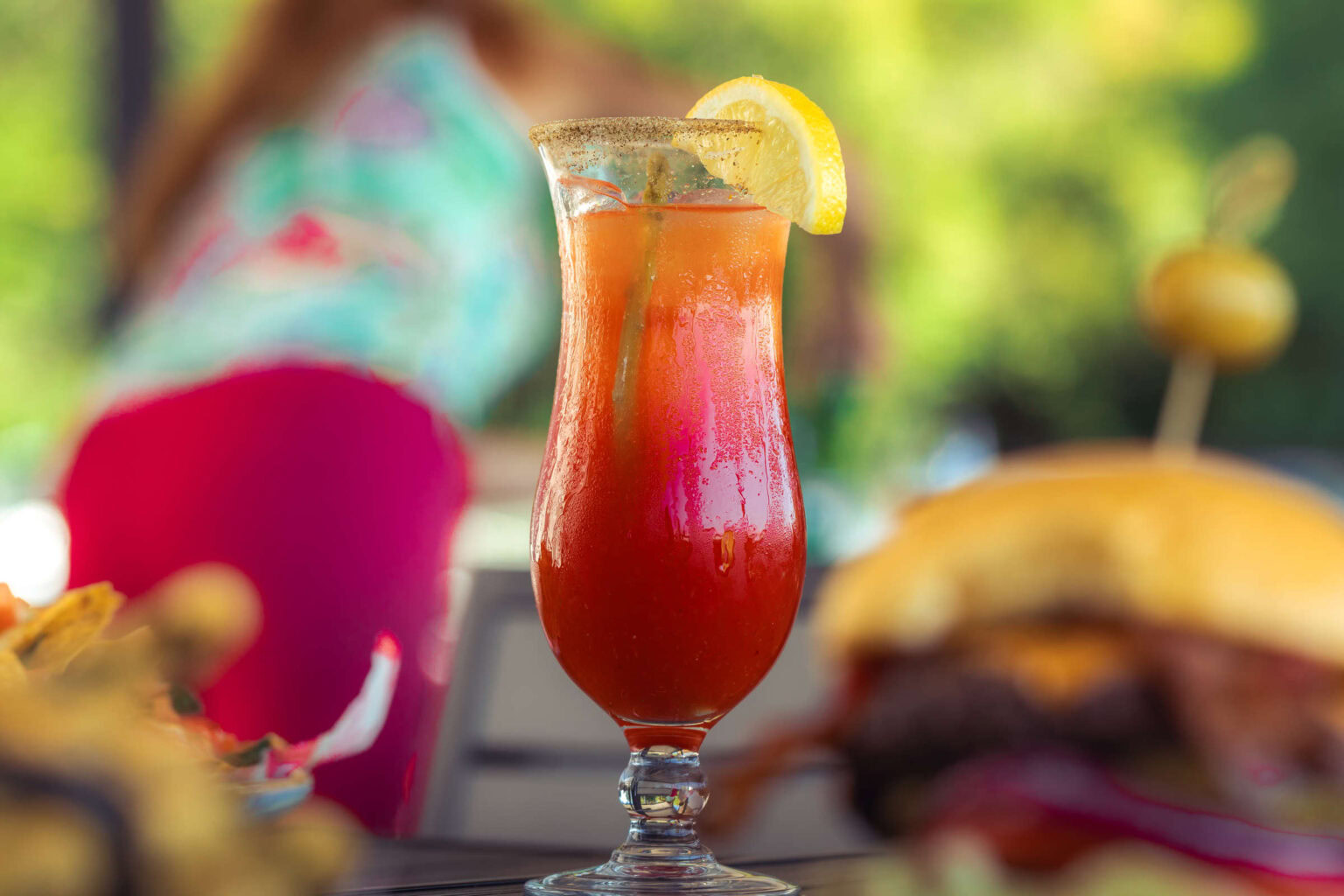 Tropical cocktail with lemon slice at Highlands Golf Club in outdoor setting.