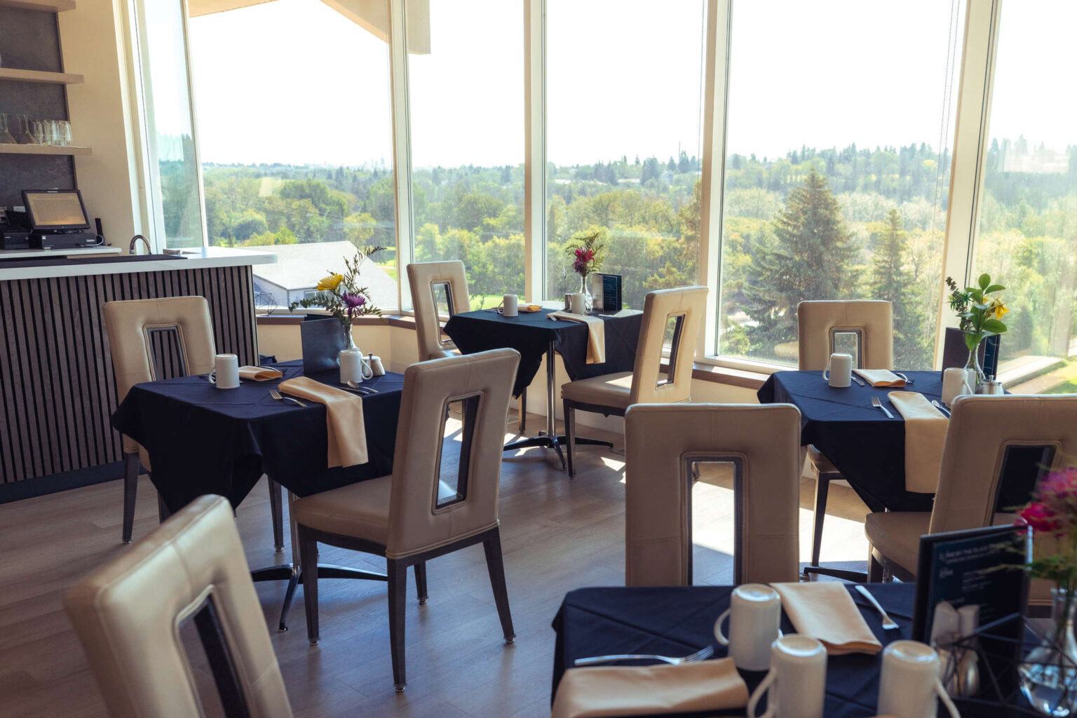 Elegant golf clubhouse dining area overlooking scenic greenery, perfect for events.