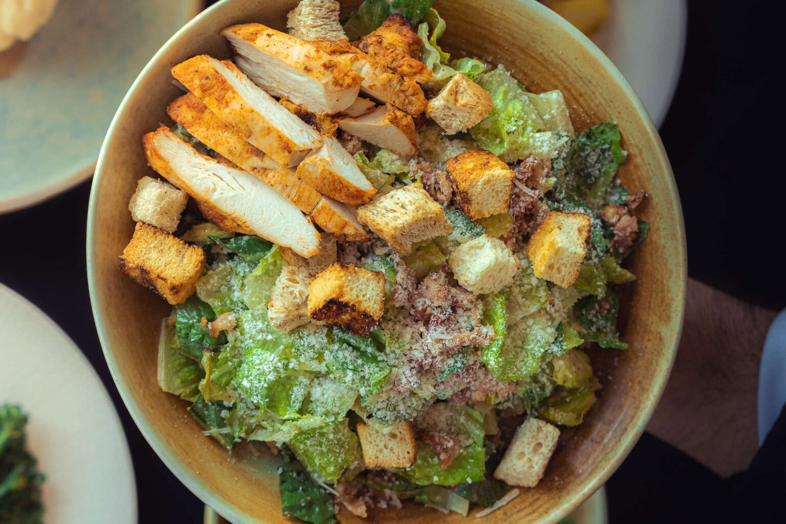 Fresh Caesar salad with grilled chicken, croutons, and parmesan cheese at Highlands Golf Club.