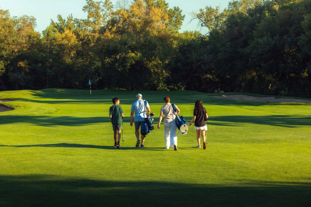 Golf course with golfers walking on the fairway at Highlands Golf Club.