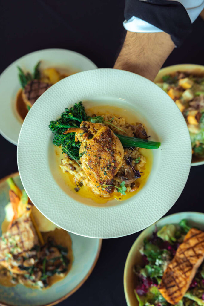 Elegant golf clubhouse dining with gourmet dishes at Highlands Golf Club.